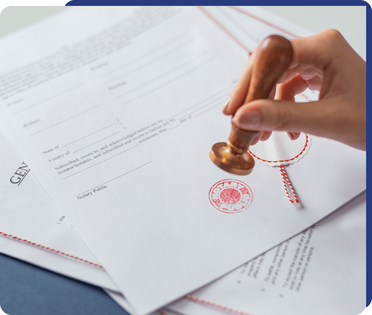 A hand stamping an official document with a red seal.